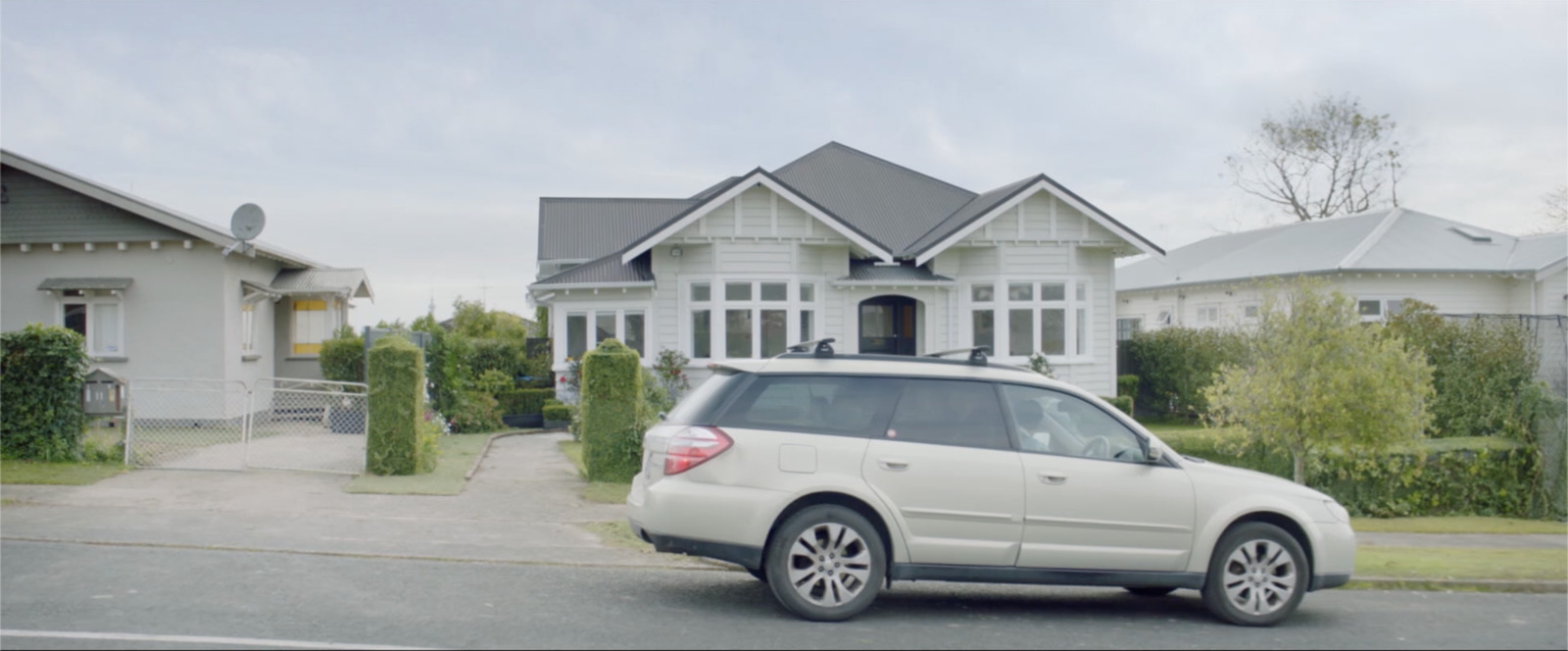 a white car parked in front of a house