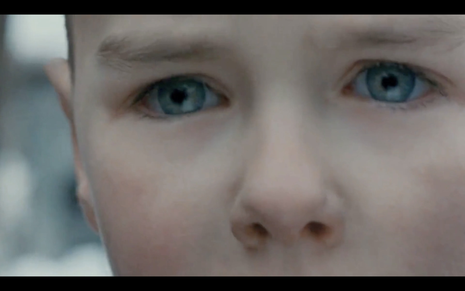 a close up of a child's face with blue eyes