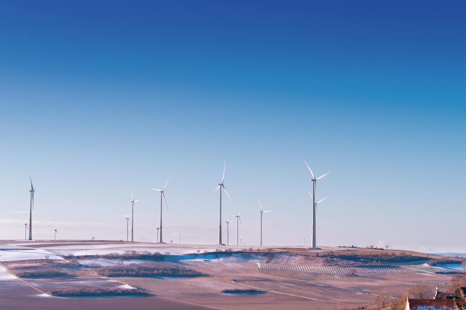 a row of wind turbines on top of a hill