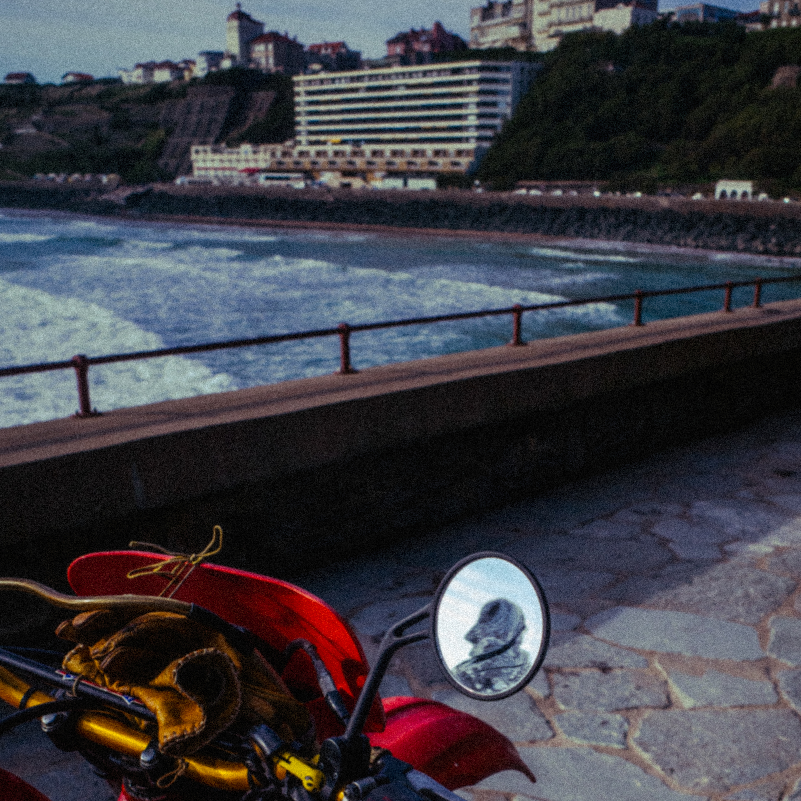 a motorcycle parked on the side of a road next to the ocean