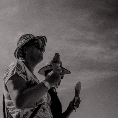 a woman holding a banana while wearing a hat