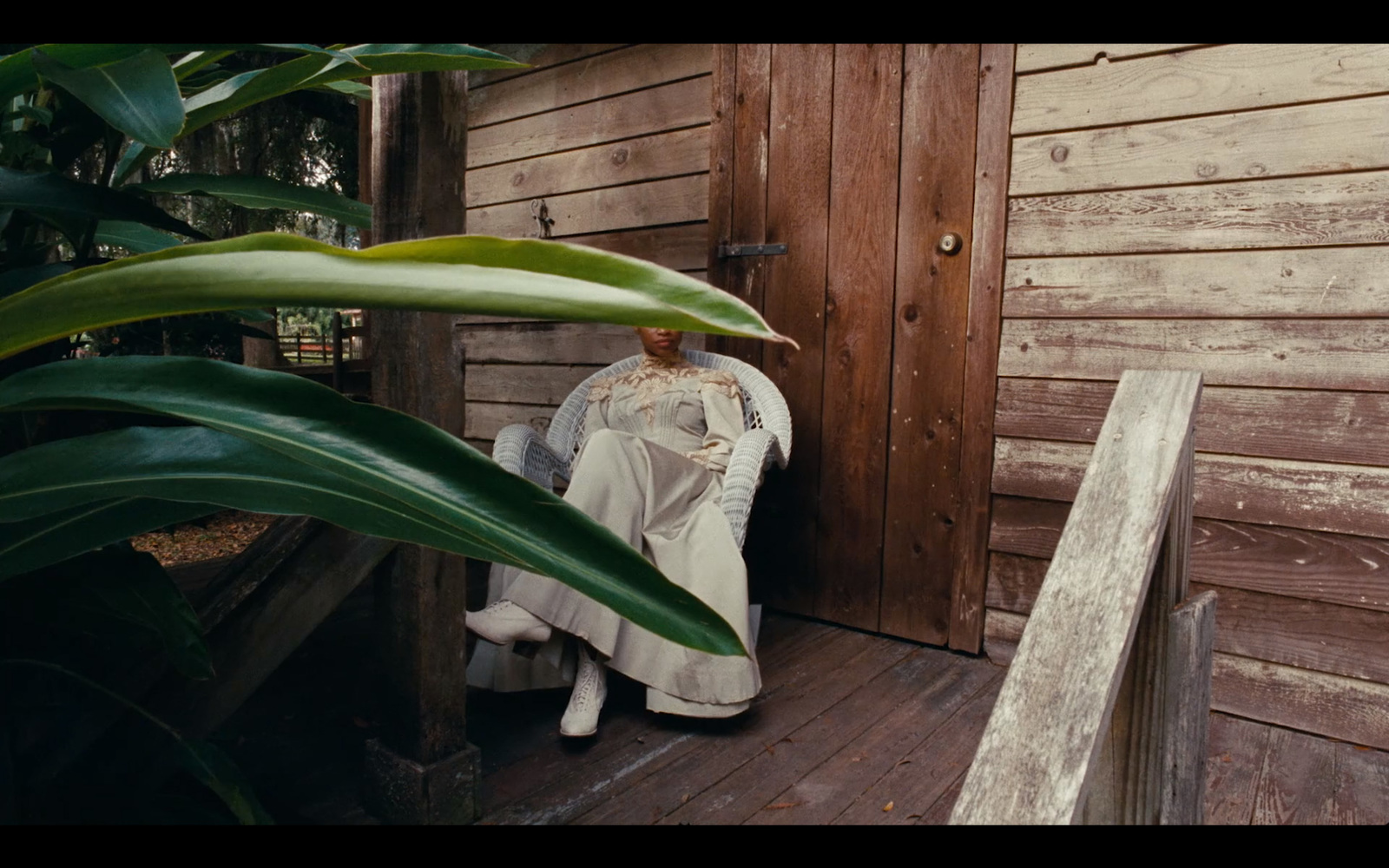 a statue of a woman in a white dress sitting on a porch