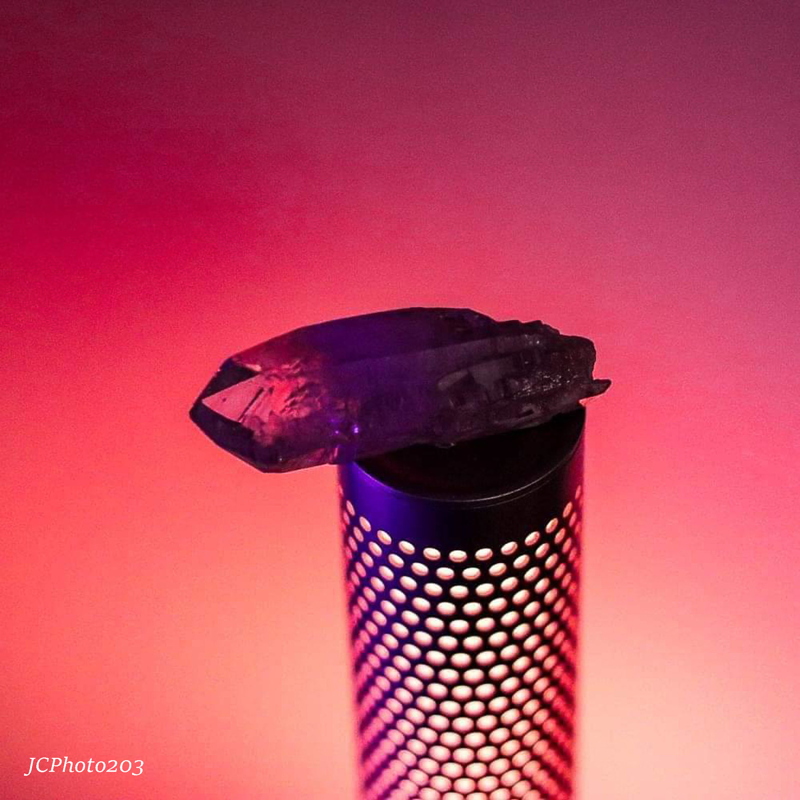 a close up of a metal object on a pink background