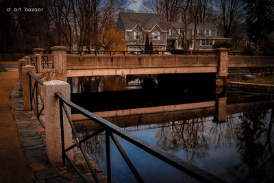 a bridge over a body of water with houses in the background