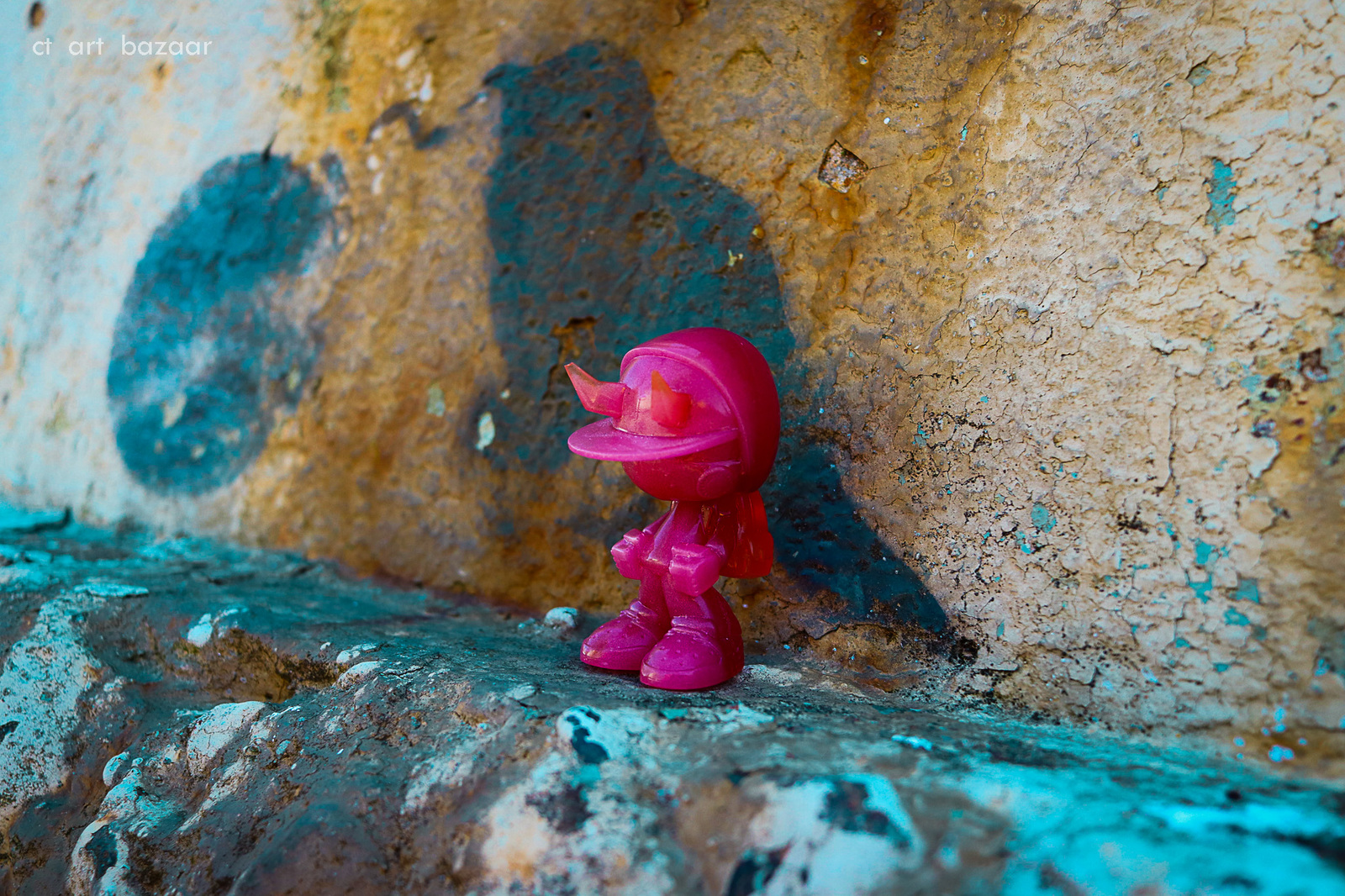 a pink toy sitting on top of a stone wall