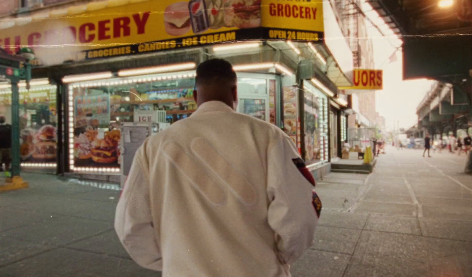 a man walking down the street in front of a grocery store