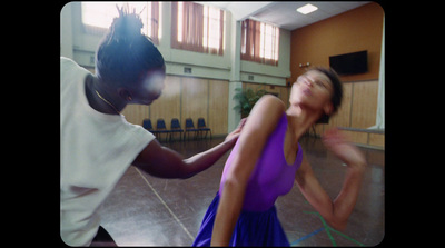 a woman in a purple dress dancing with a man in a white shirt