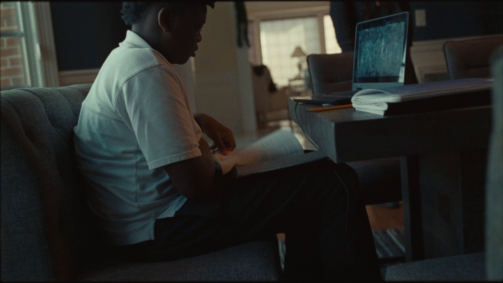 a man sitting on a couch reading a book