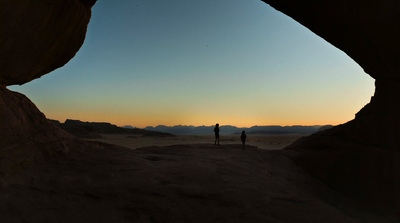 a couple of people standing in the middle of a desert