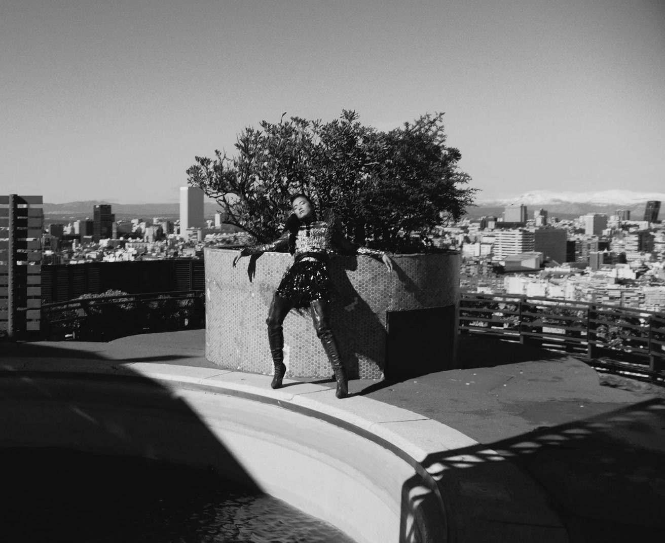 a man standing on top of a building next to a tree