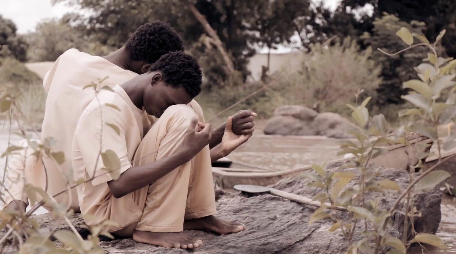 a couple of people sitting on top of a rock