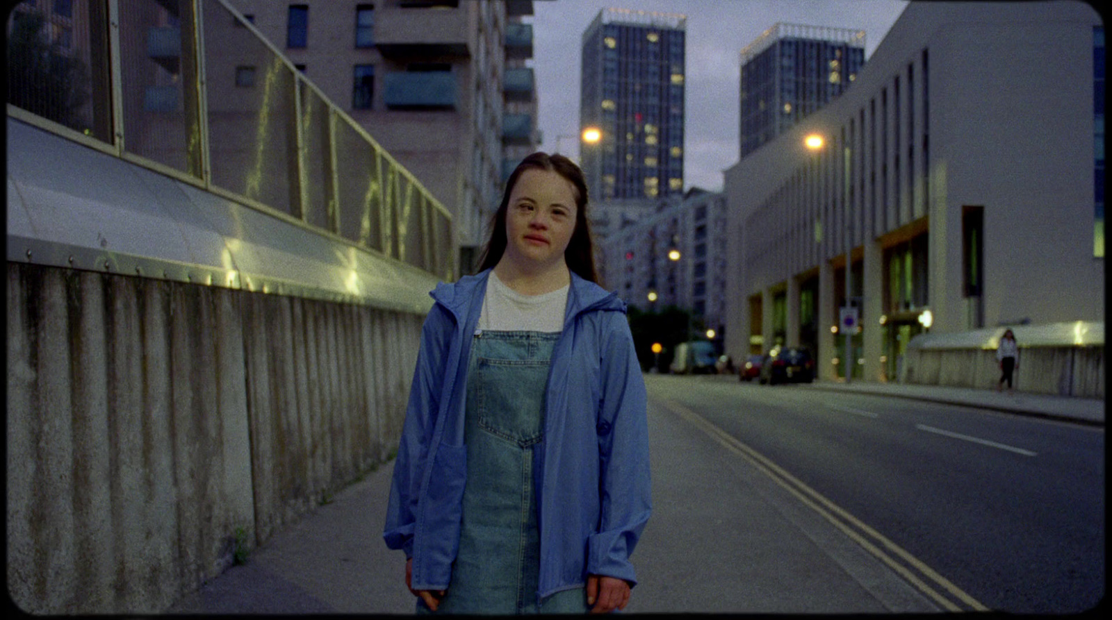 a woman standing on a sidewalk in a city