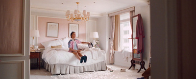 a woman sitting on a bed in a bedroom