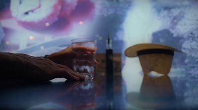 a person holding a glass of beer on a table