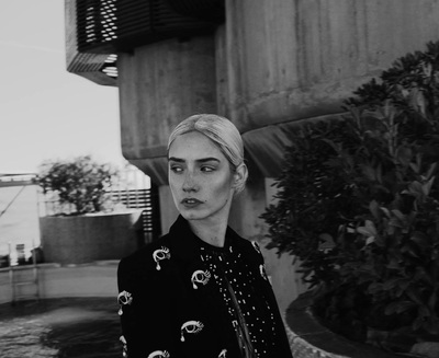 a black and white photo of a woman in front of a building