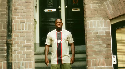 a young man standing in front of a door