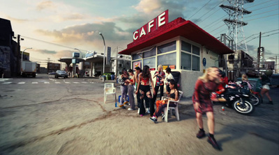 a group of people standing in front of a cafe