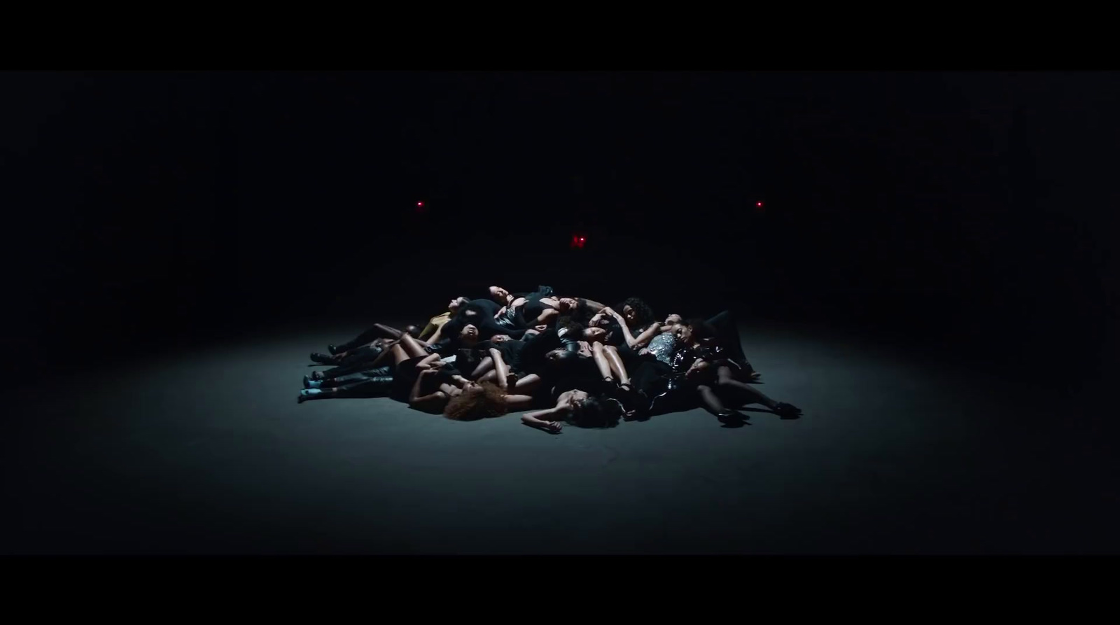 a group of people laying on the ground in the dark