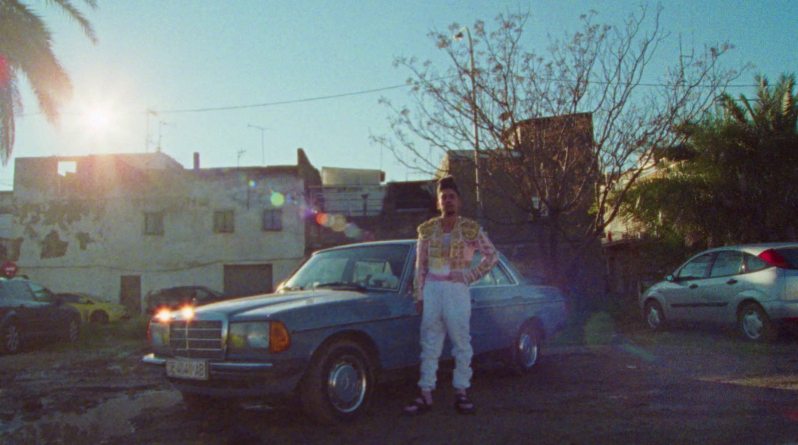 a man standing next to a car in a parking lot