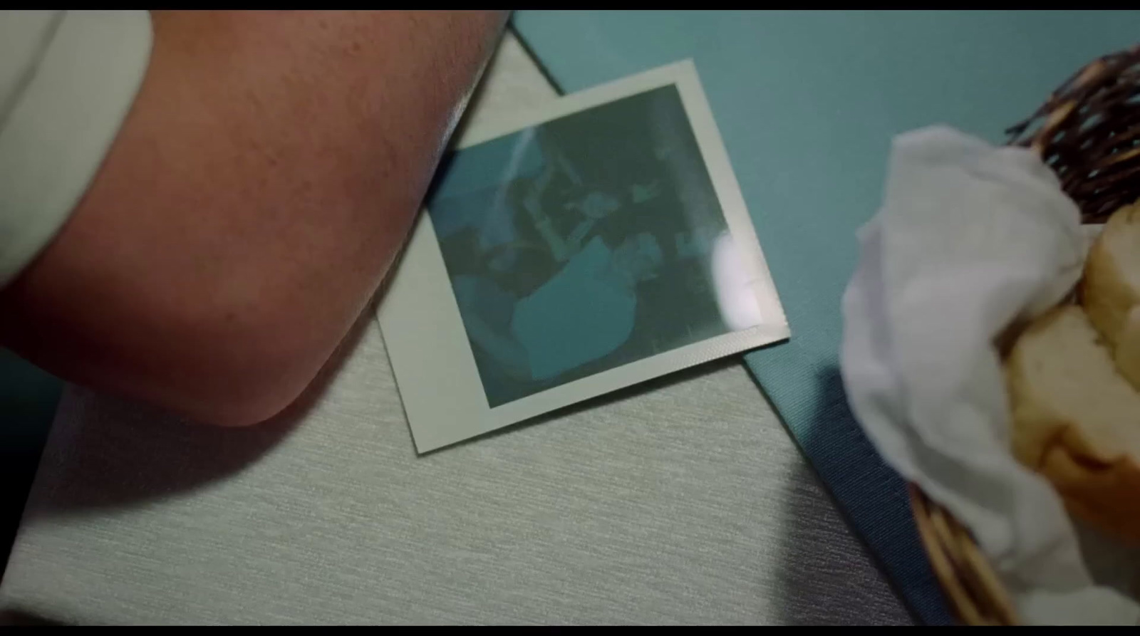 a picture of a man and a woman on a table next to a basket of