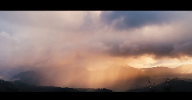 the sun is shining through the clouds in the mountains