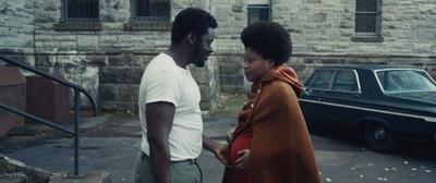 a man and a woman standing in front of a car