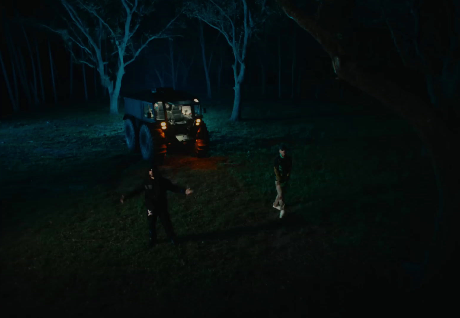 a group of people standing in the dark near a truck