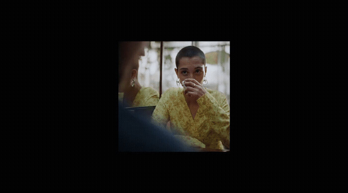 a woman in a yellow shirt smoking a cigarette