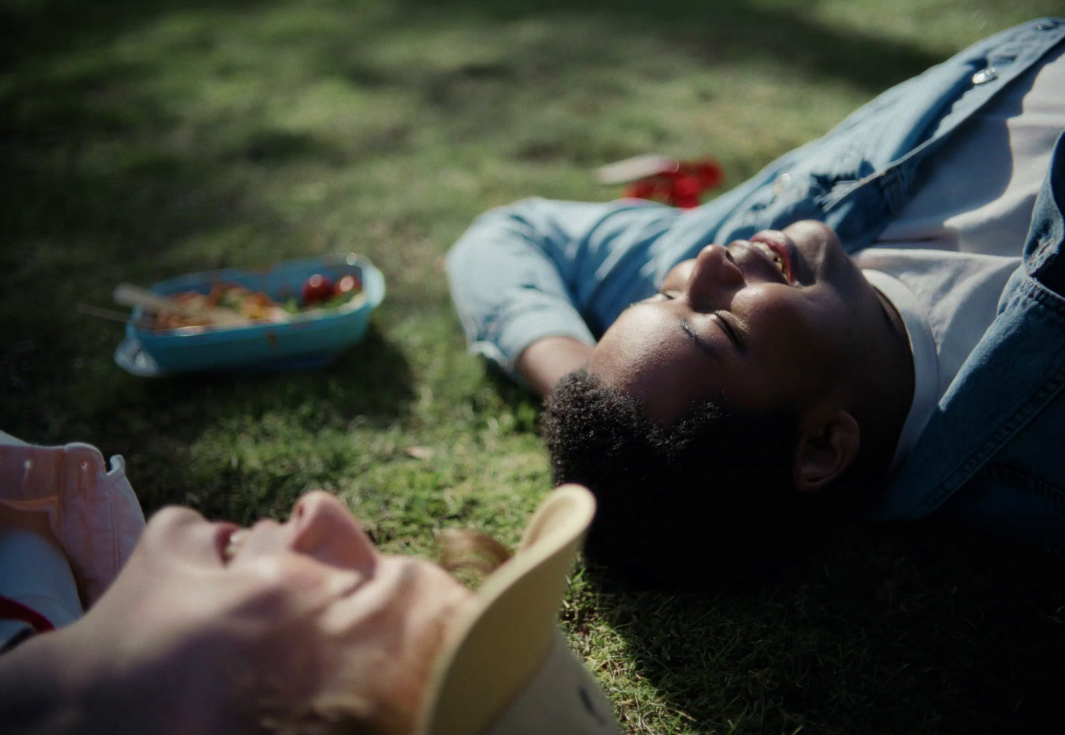 a man laying on the ground next to a bowl of food