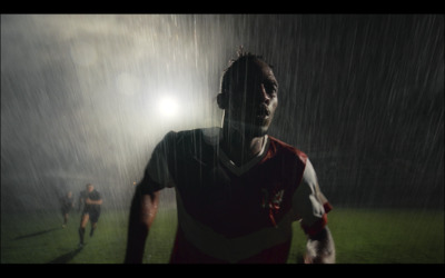 a soccer player is running in the rain