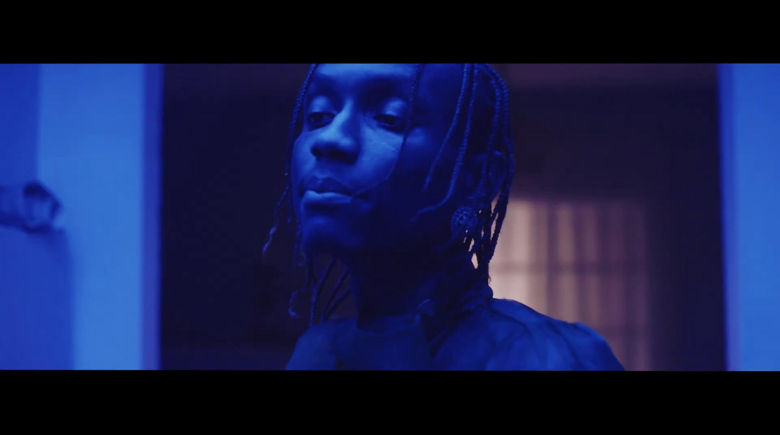 a man with dreadlocks standing in a room