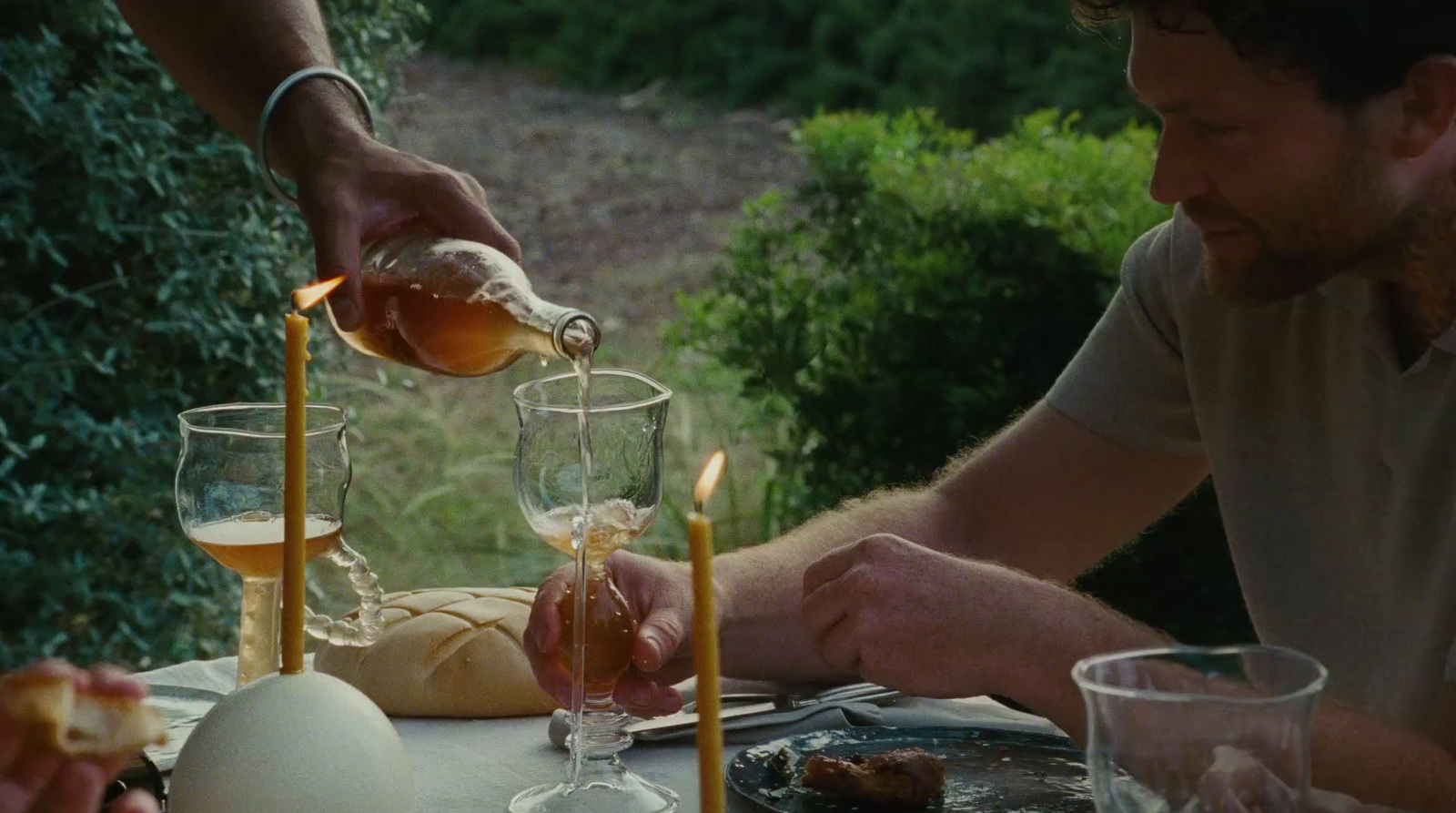 a man pouring wine into a glass at a table