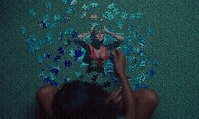 a woman laying on the ground surrounded by blue puzzle pieces