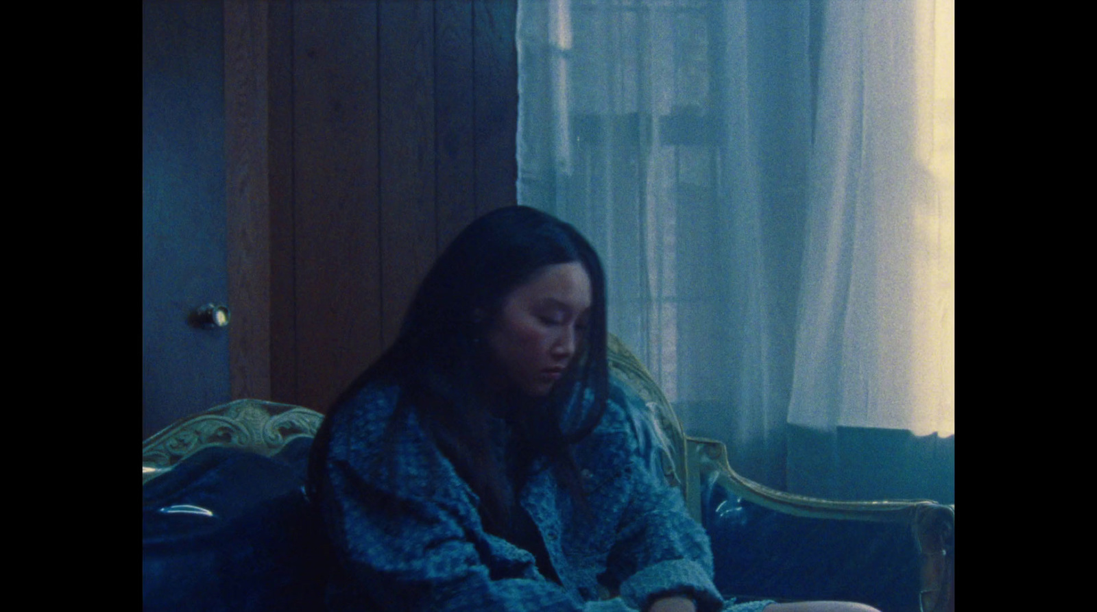 a woman sitting on a couch in front of a window