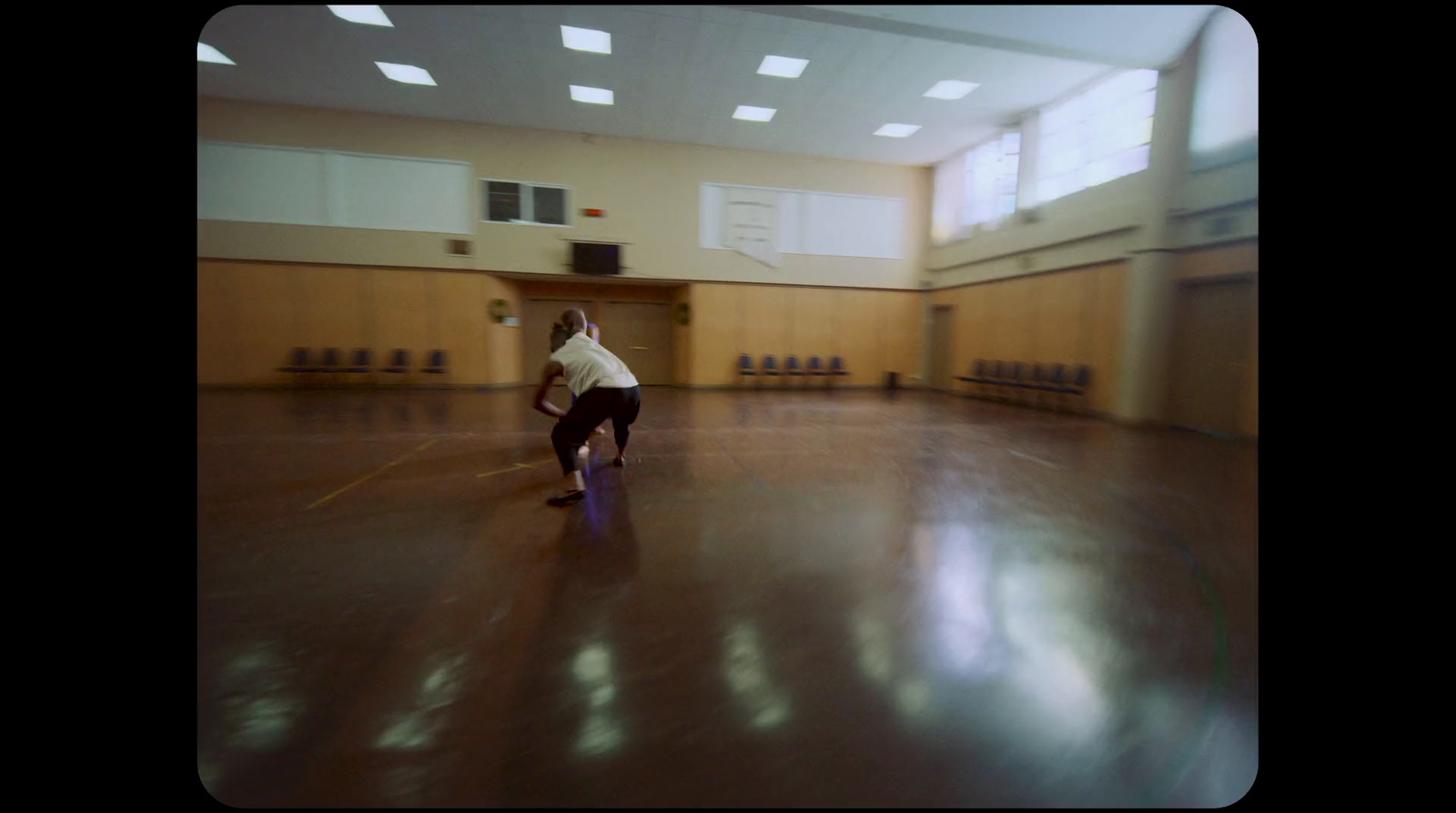 a man riding a skateboard on top of a hard wood floor