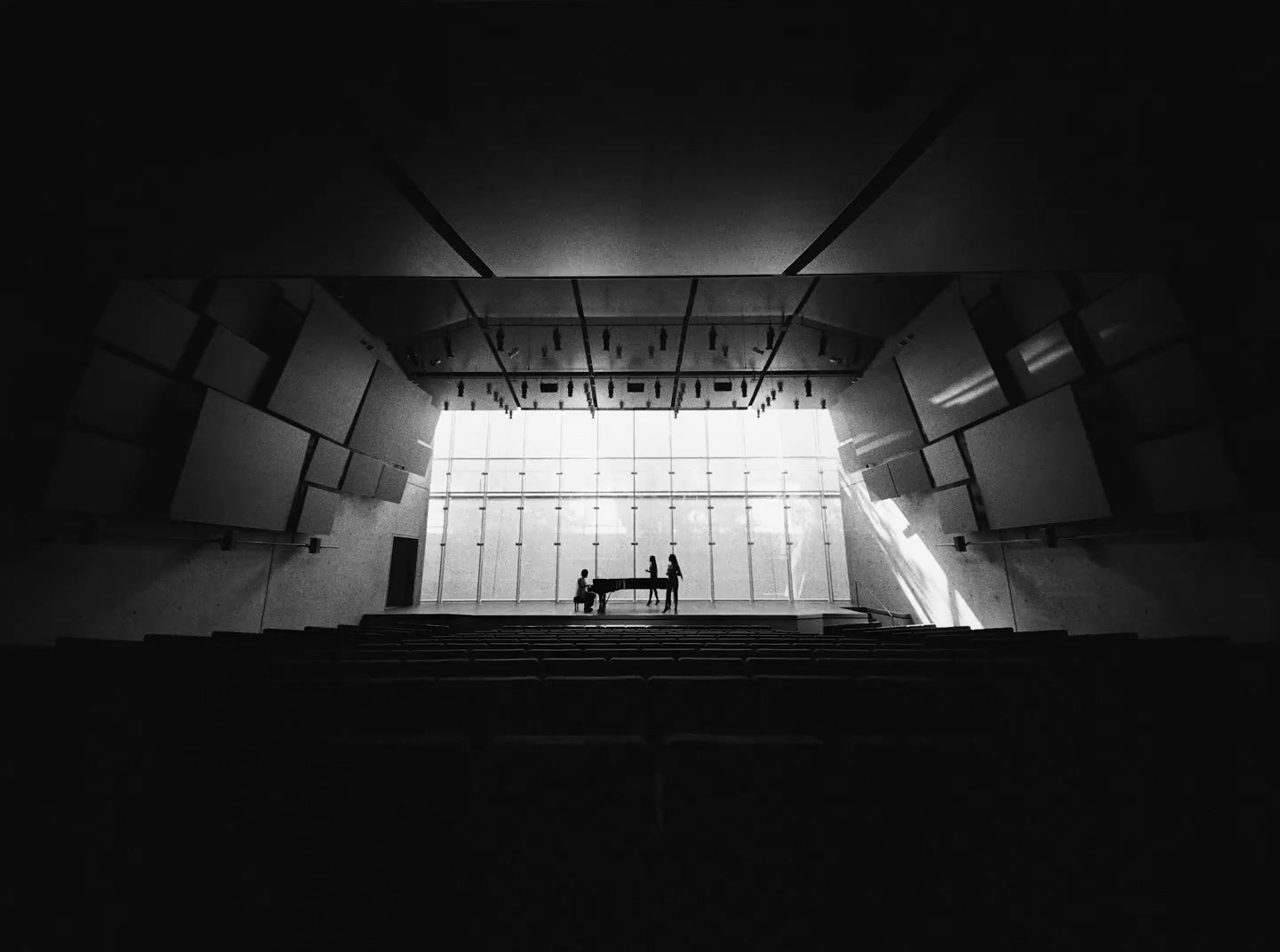 a black and white photo of a person sitting on a bench