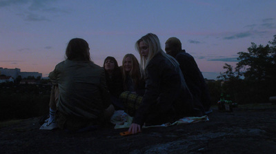 a group of people sitting on top of a hill