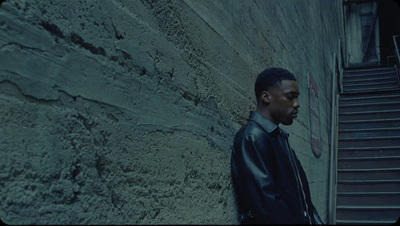 a man standing in front of a stone wall