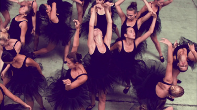 a group of women in black dresses dancing together