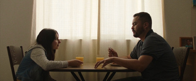 a man and a woman sitting at a table with orange juice