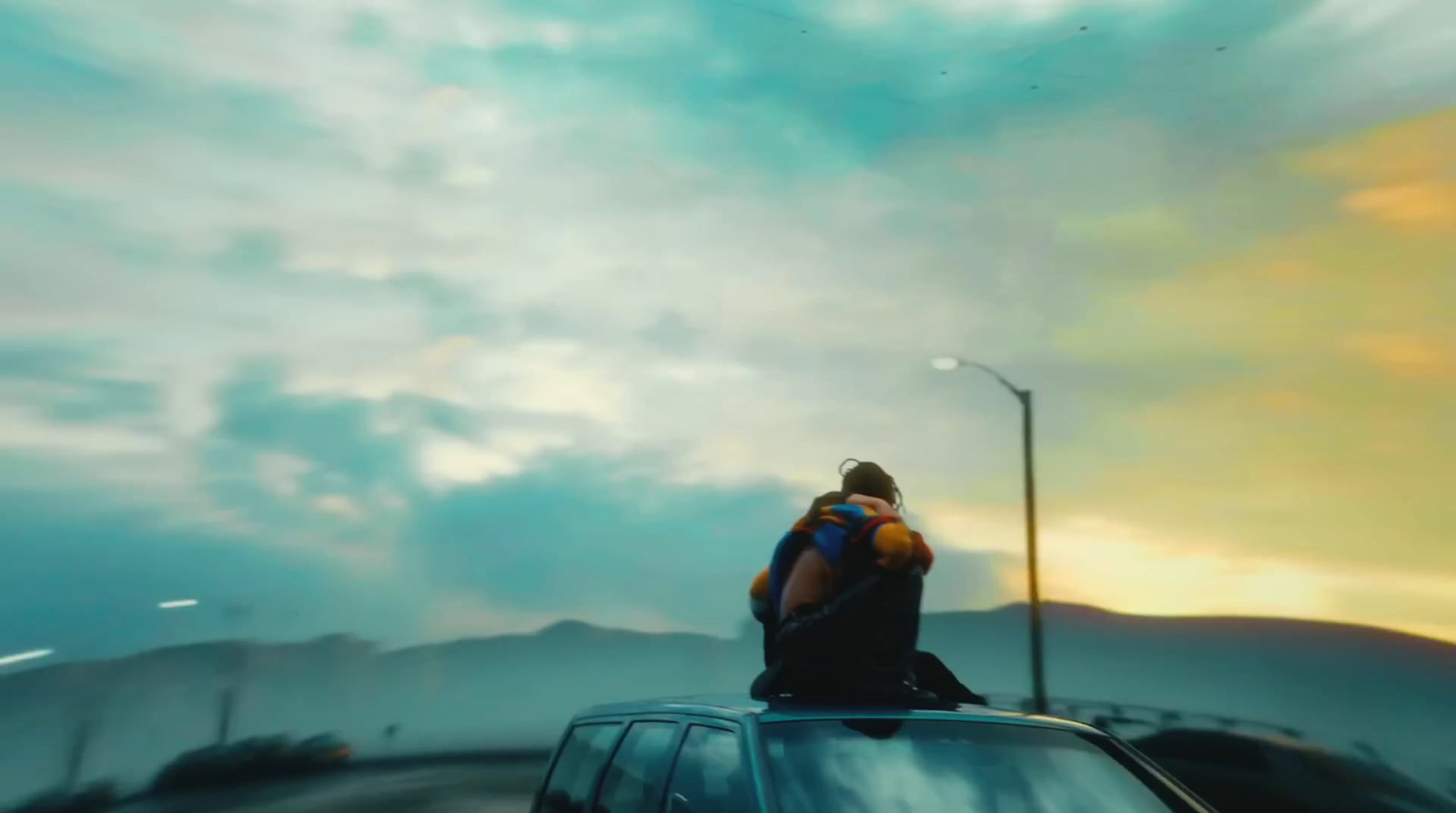 a man sitting on the roof of a car