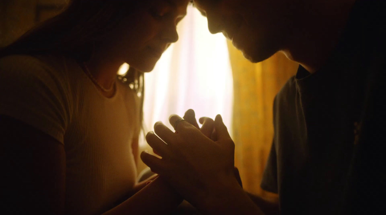 a man and a woman praying in a dark room