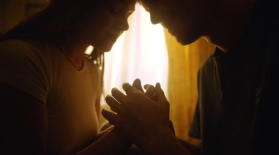 a man and a woman praying in a dark room