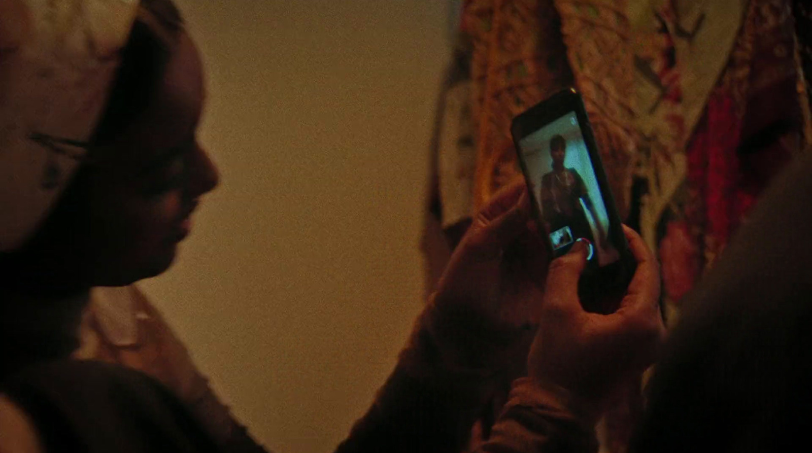 a person holding a cell phone up to their face