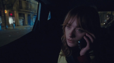 a woman sitting in a car talking on a cell phone