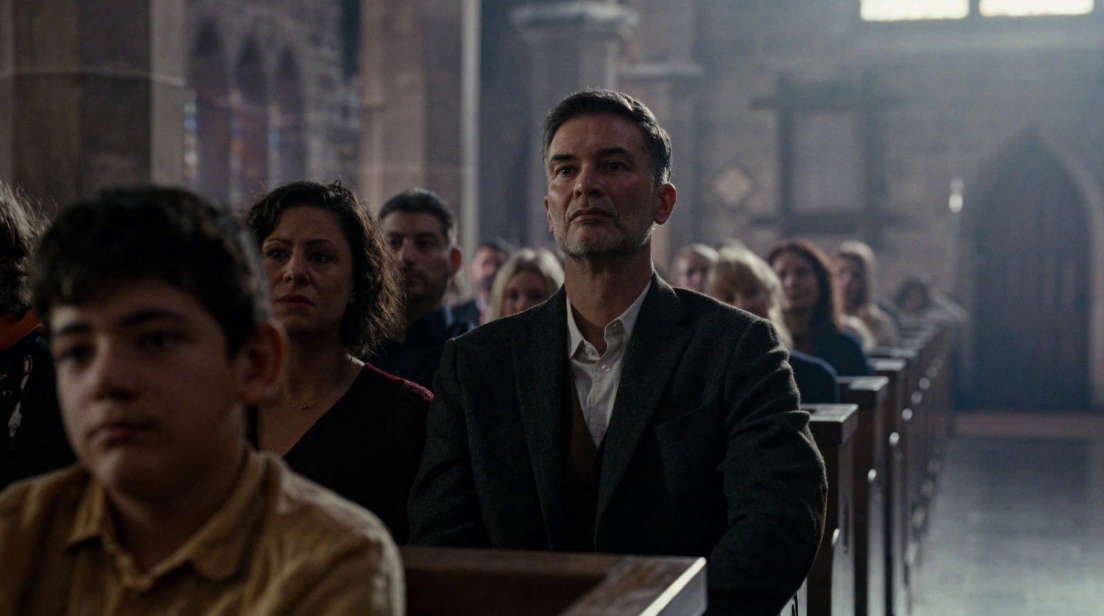 a group of people sitting in pews in a church