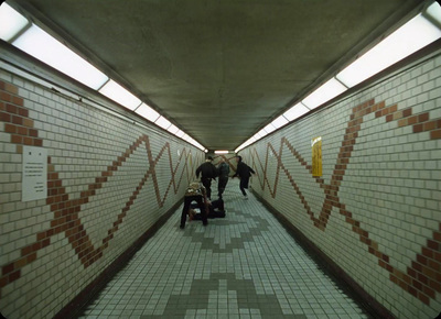 a group of people walking down a long hallway