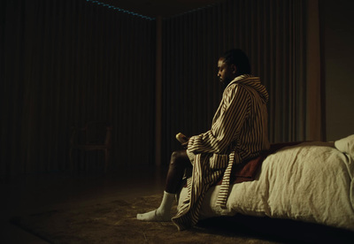 a man sitting on a bed in a dark room