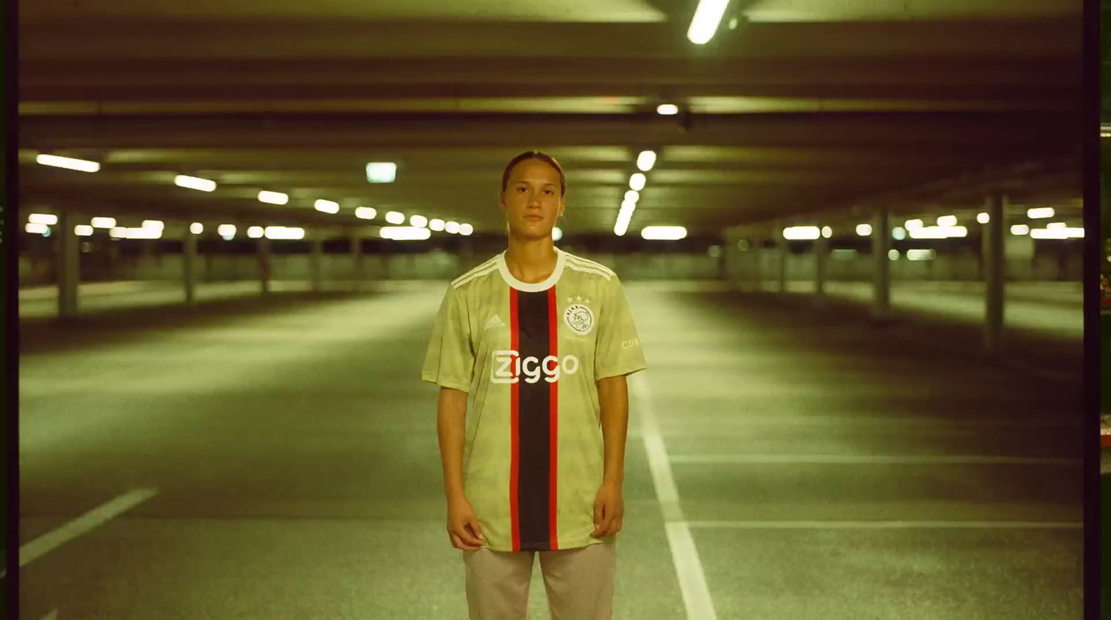 a young man standing in a parking garage