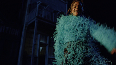 a woman in a blue feathered dress